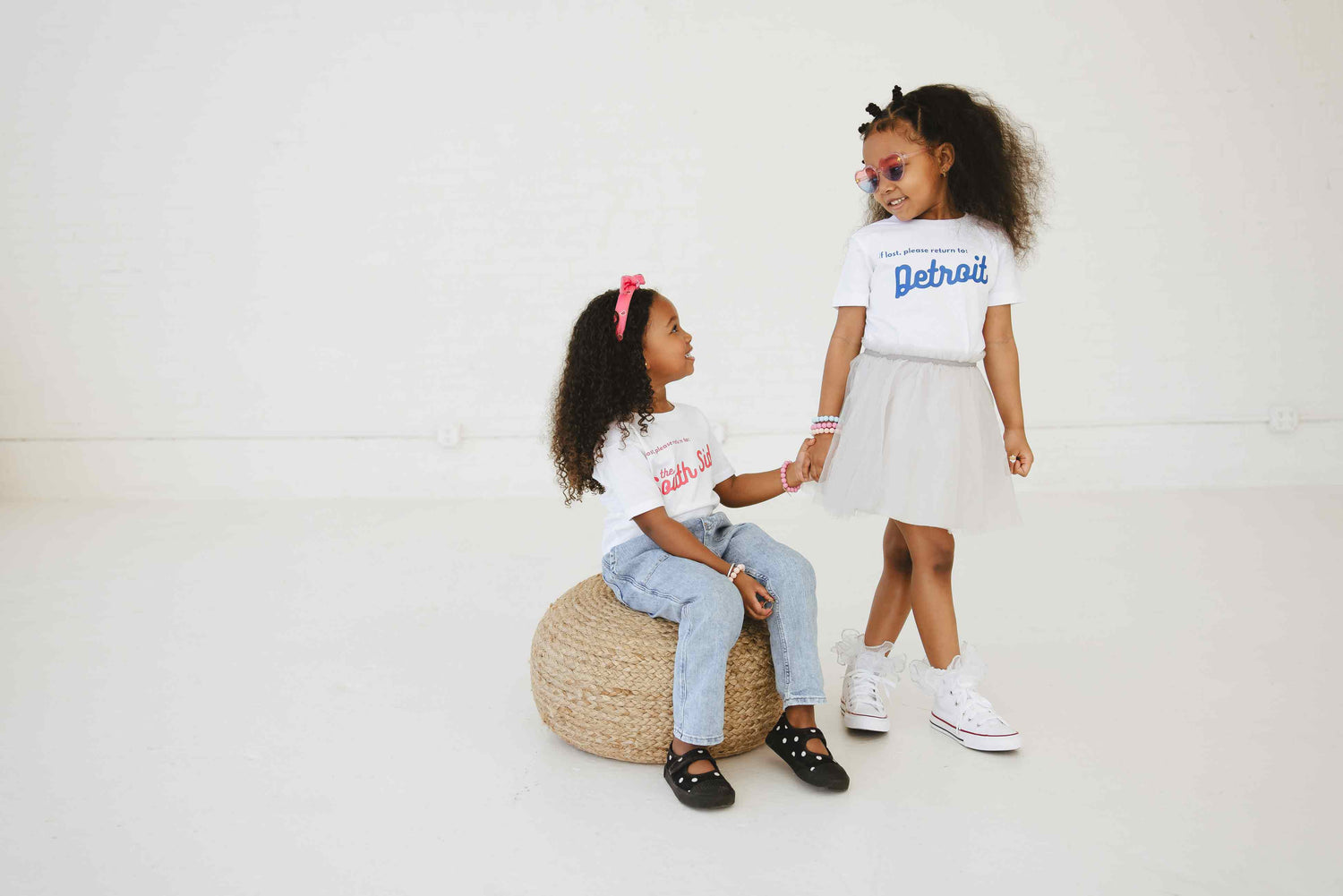 Two Girls Holding Hands Wearing Evanruby Tees